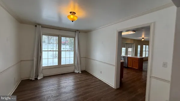 an empty room with wooden floor and a window