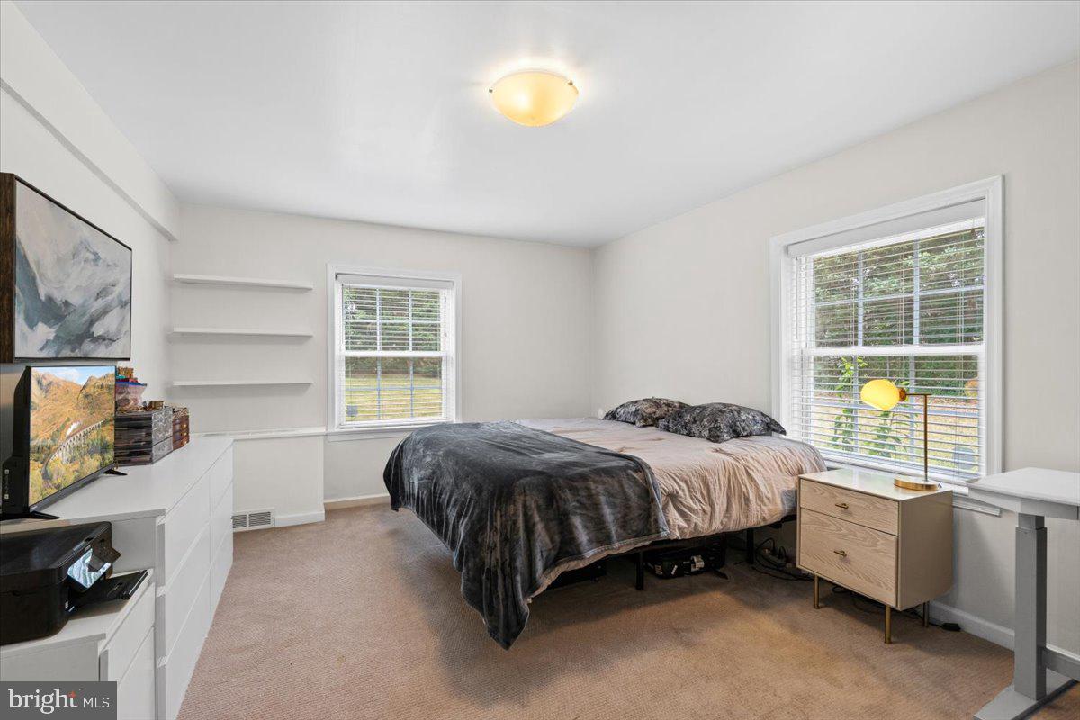 3332 Spring Lane, Unit C10 Falls Church, VA 22041 - Photo 22 of 25 a spacious bedroom with a bed and a flat tv screen on the dresser
