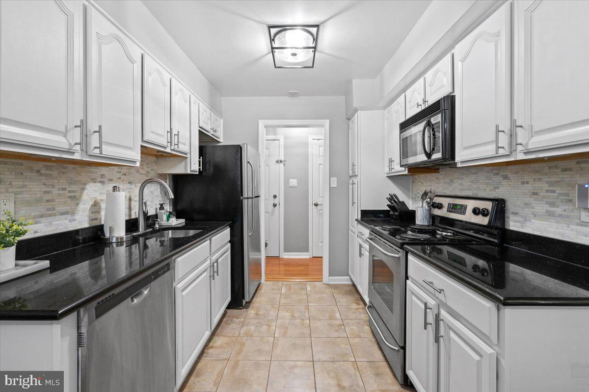 3332 Spring Lane, Unit C10 Falls Church, VA 22041 - Photo 7 of 25 a kitchen with stainless steel appliances granite countertop a stove a sink dishwasher and a refrigerator