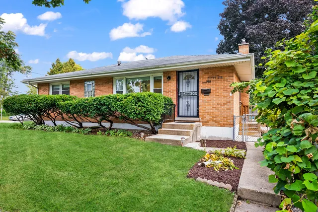 a front view of a house with a garden and plants