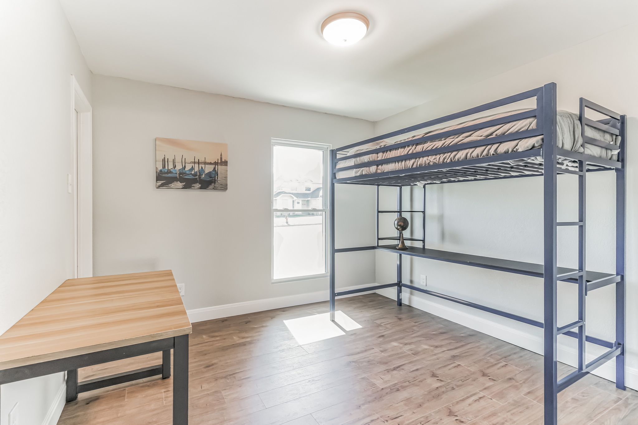 11406 Ruffed Grouse Drive Austin, TX 78758 - Photo 19 of 22 Warm wood-look flooring and a bright single window anchor this versatile secondary bedroom.