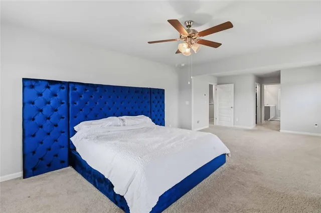 a bed room with a bed and a ceiling fan