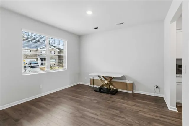 a view of a room with wooden floor and a window