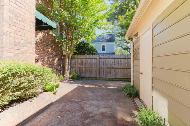 a view of house with a small yard and wooden fence