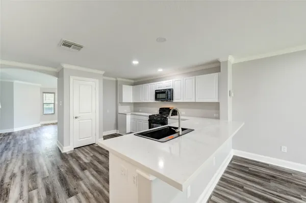a kitchen with cabinets and wooden floor