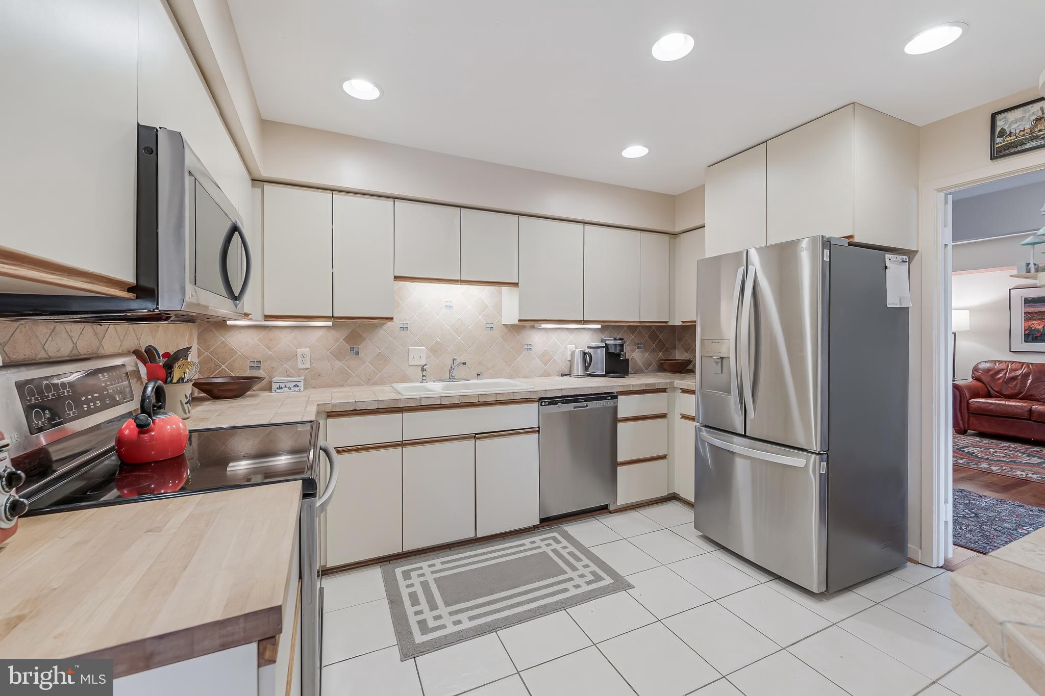 11500 Fairway Drive, Unit 507 Reston, VA 20190 - Photo 13 of 41 a kitchen with granite countertop a refrigerator oven a sink dishwasher and a refrigerator with wooden cabinets
