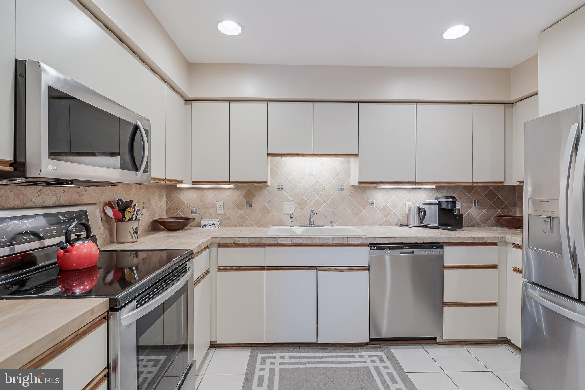 11500 Fairway Drive, Unit 507 Reston, VA 20190 - Photo 14 of 41 a kitchen with a sink dishwasher stove and white cabinets