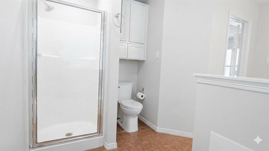 211 Vista Ridge Drive Venus, TX 76084 - Photo 14 of 24 Walk-in shower with clear glass enclosure and white subway tile surround, complemented by a white toilet and built-in white cabinetry