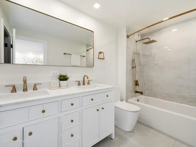 a bathroom with a granite countertop sink a toilet and a bathtub
