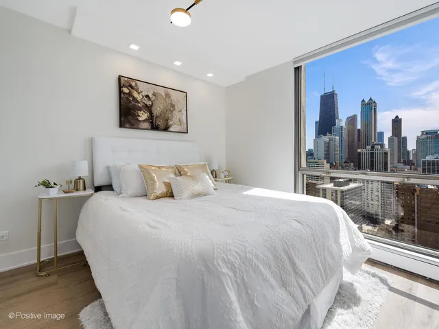 a bedroom with a large bed and a chandelier