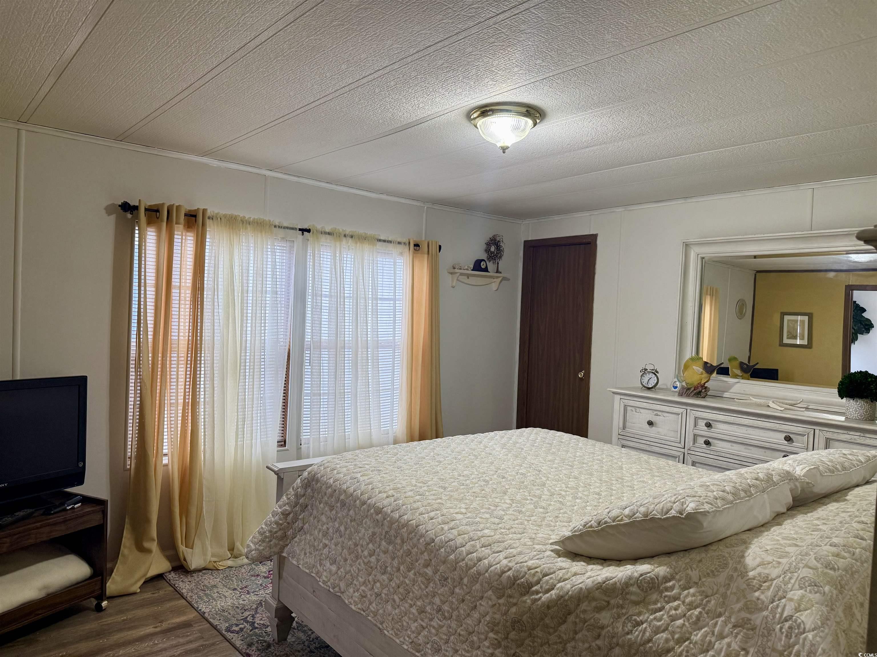 1801 E Lake Surfside Beach, SC 29575 - Photo 12 of 32 Bedroom with wood finished floors and a textured ceiling