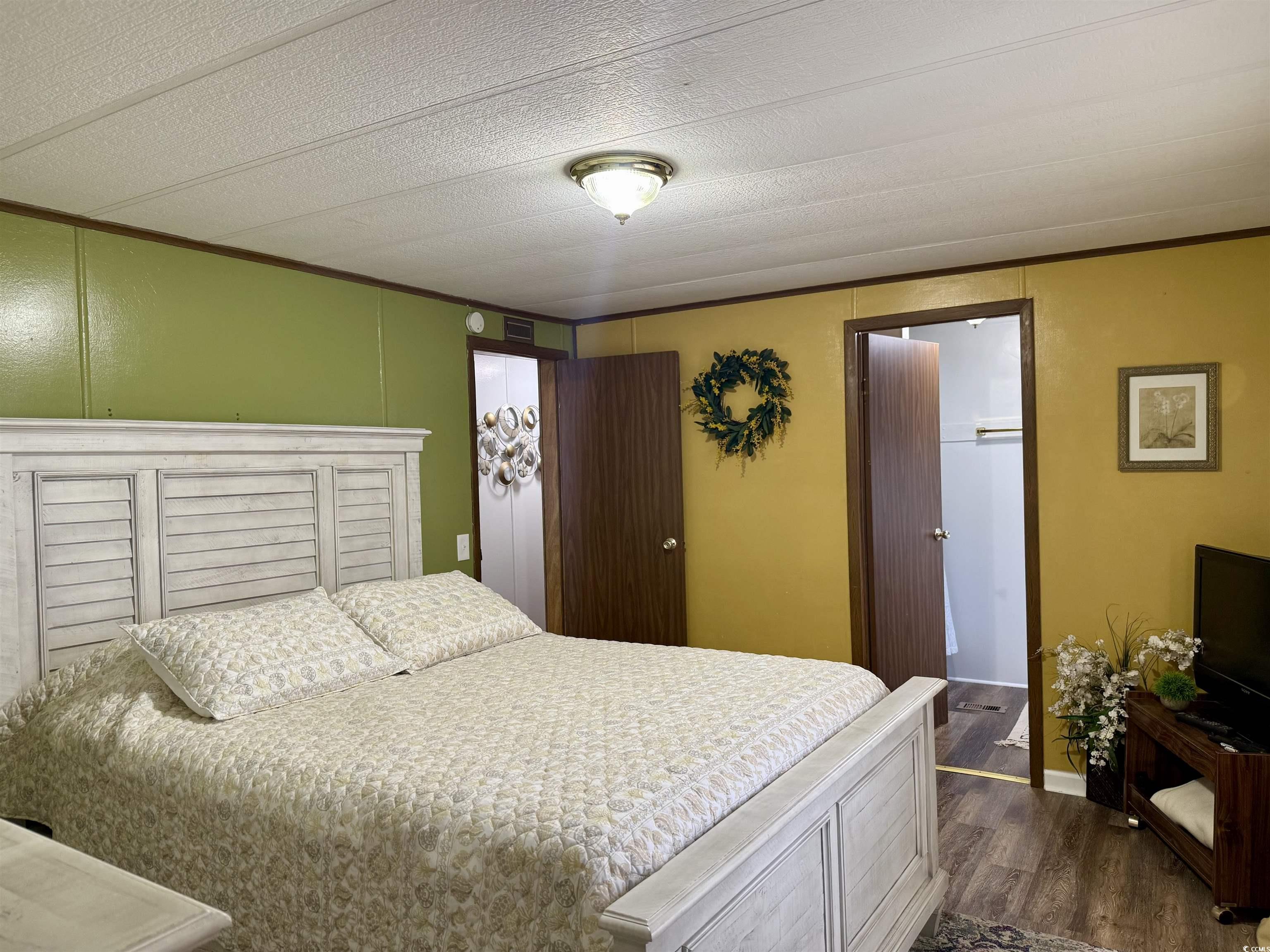 1801 E Lake Surfside Beach, SC 29575 - Photo 16 of 32 Bedroom featuring crown molding, dark wood finished floors, and a textured ceiling