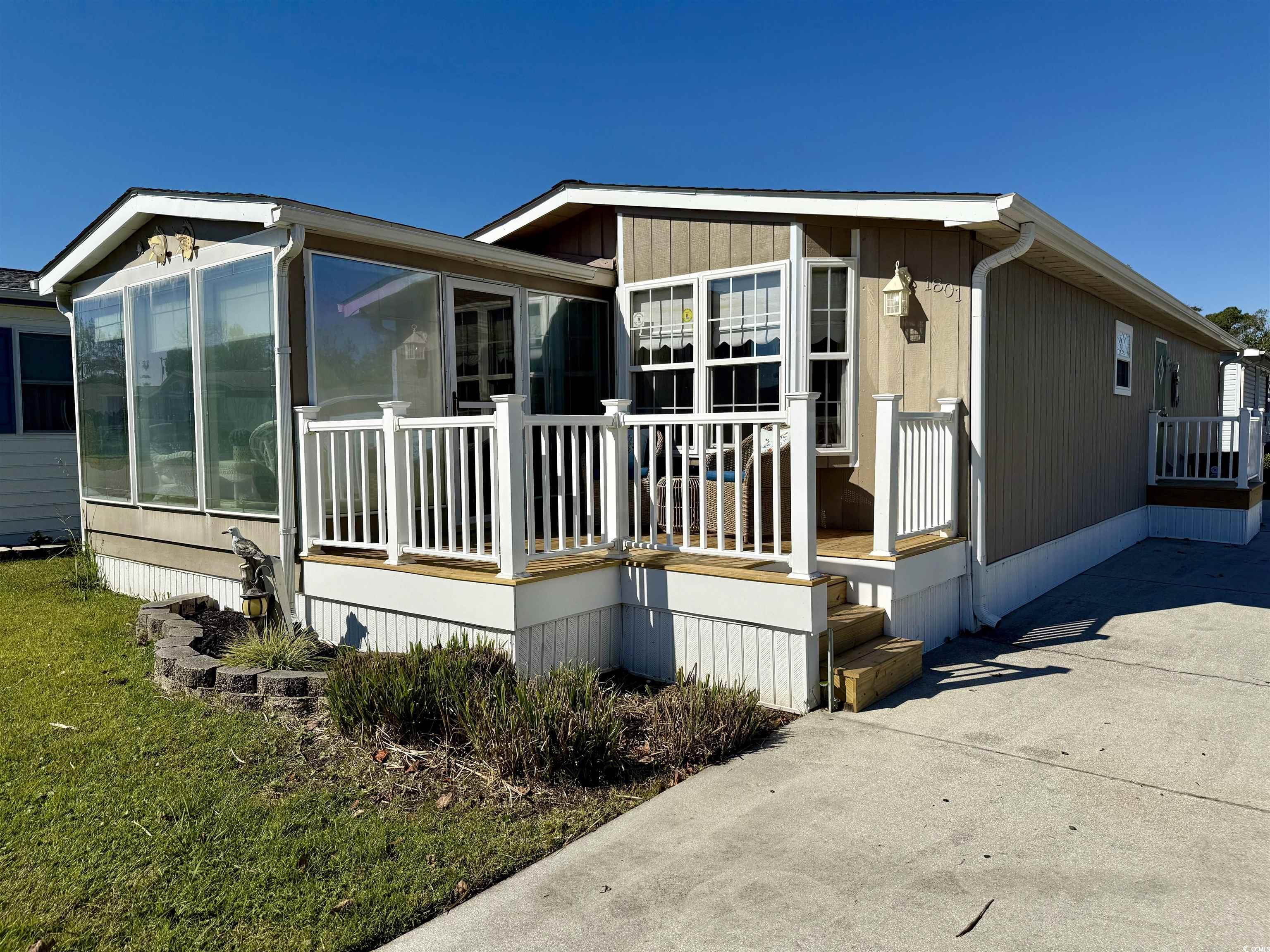 1801 E Lake Surfside Beach, SC 29575 - Photo 26 of 32 View of side of property featuring a deck, a sunroom, and driveway
