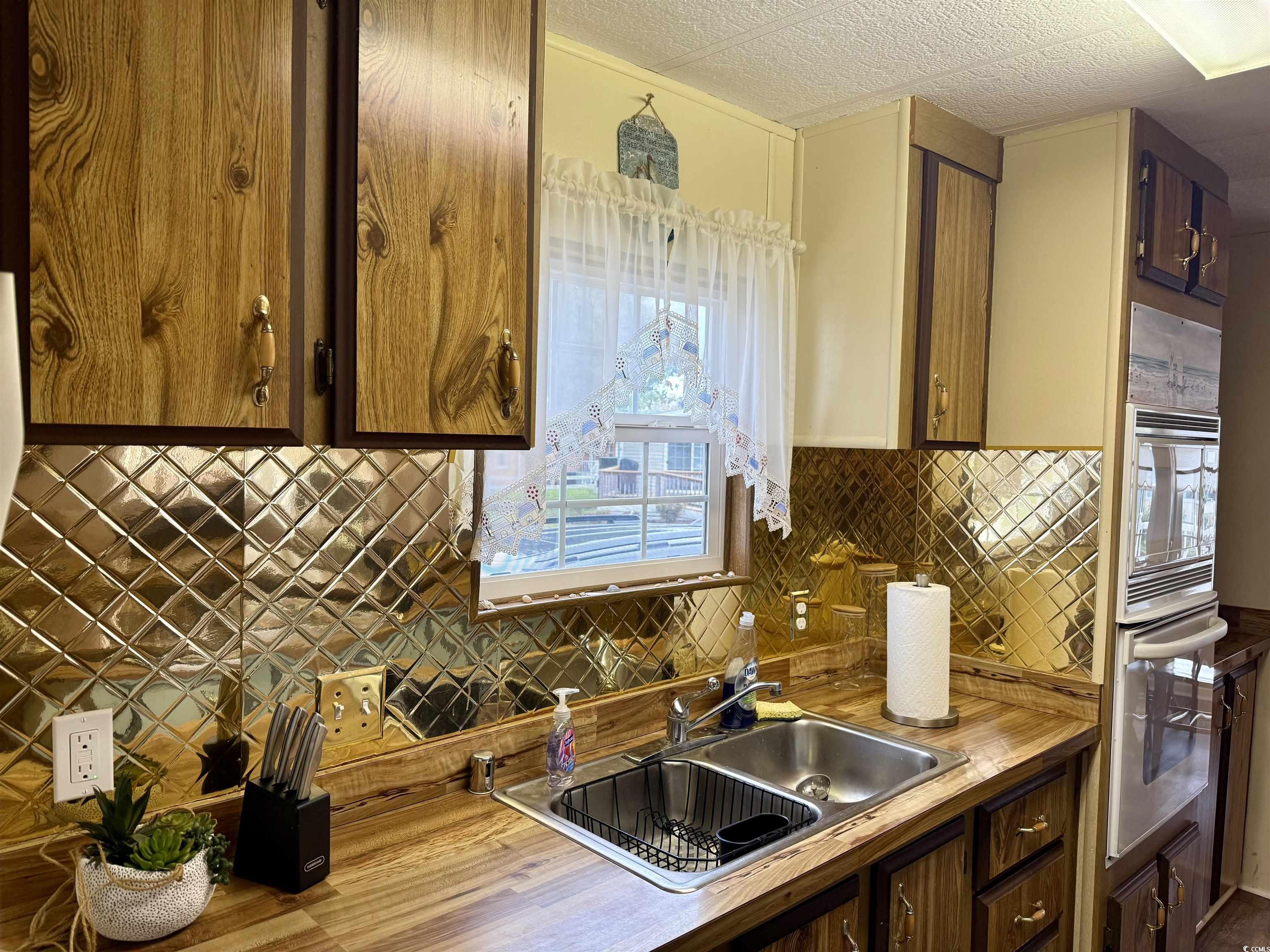 1801 E Lake Surfside Beach, SC 29575 - Photo 3 of 32 Kitchen with decorative backsplash, oven, built in microwave, light countertops, and brown cabinetry