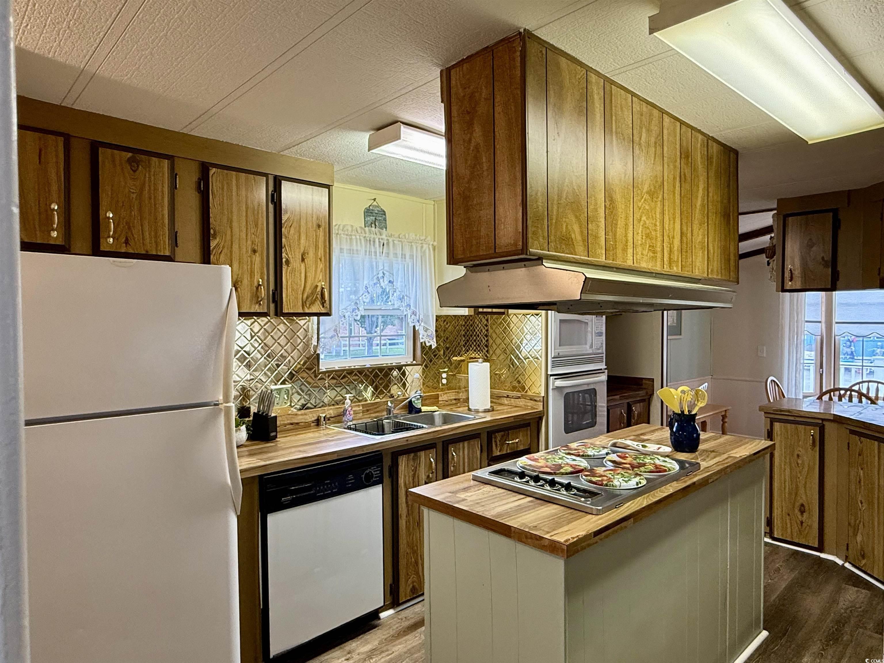1801 E Lake Surfside Beach, SC 29575 - Photo 4 of 32 Kitchen with appliances with stainless steel finishes, backsplash, a kitchen island, and light wood finished floors
