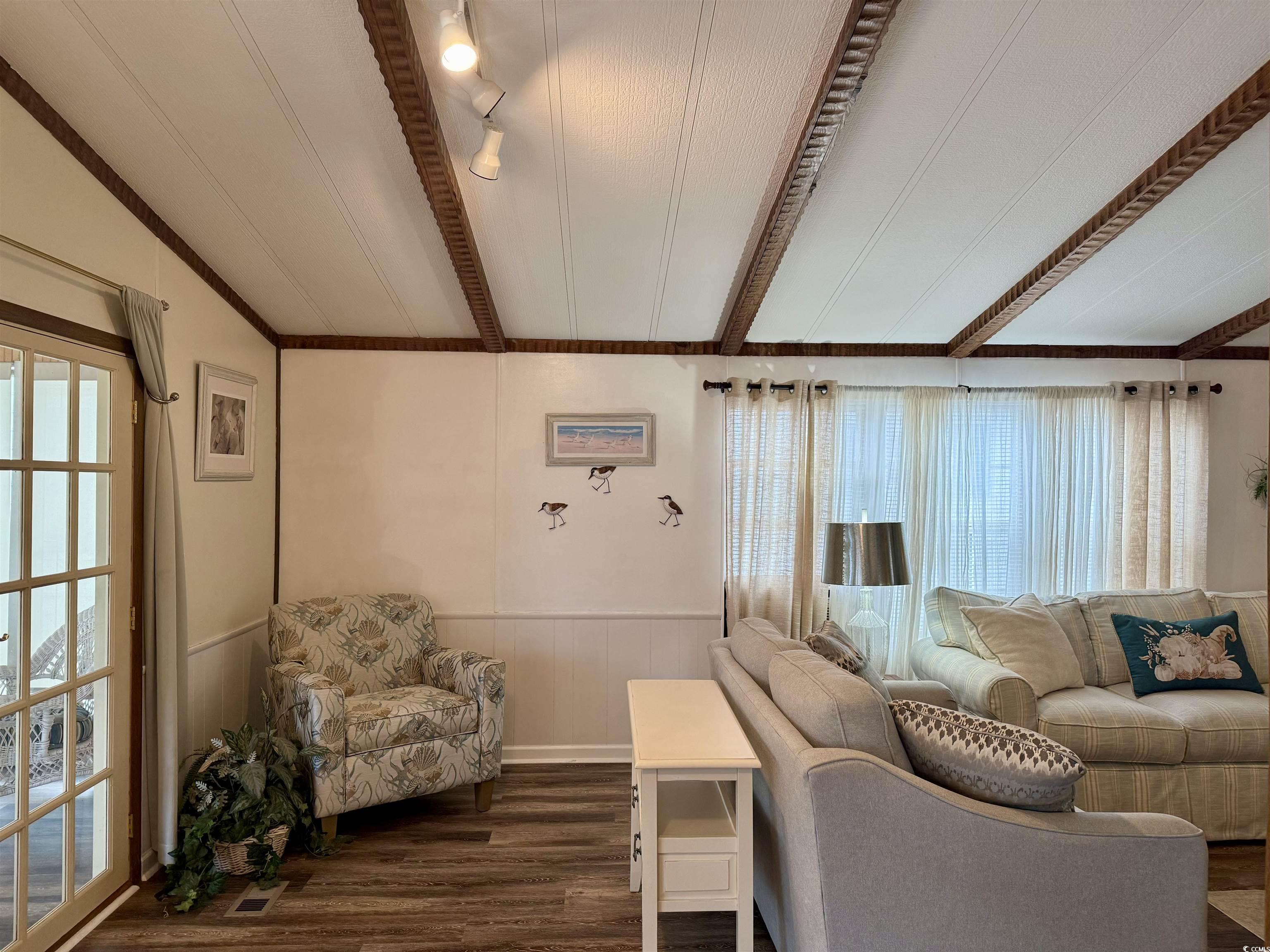 1801 E Lake Surfside Beach, SC 29575 - Photo 9 of 32 Living room with beam ceiling, wainscoting, and dark wood-style floors