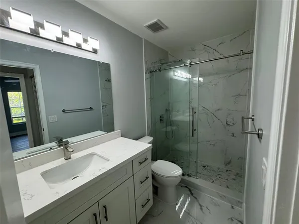 a bathroom with a sink a toilet and shower