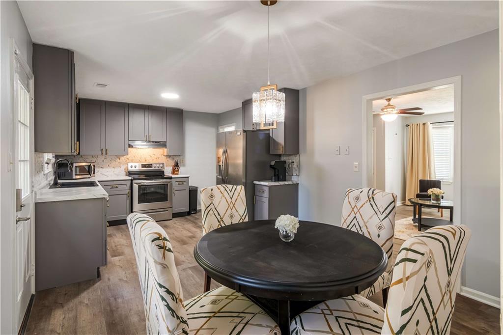 145 Mountain View Circle Covington, GA 30016 - Photo 3 of 6 a kitchen with refrigerator cabinets dining table and chairs