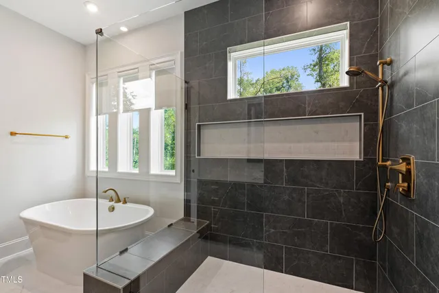a bathroom with a tub sink shower and mirror