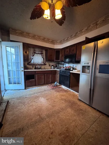 a large kitchen with stainless steel appliances granite countertop a stove and a refrigerator