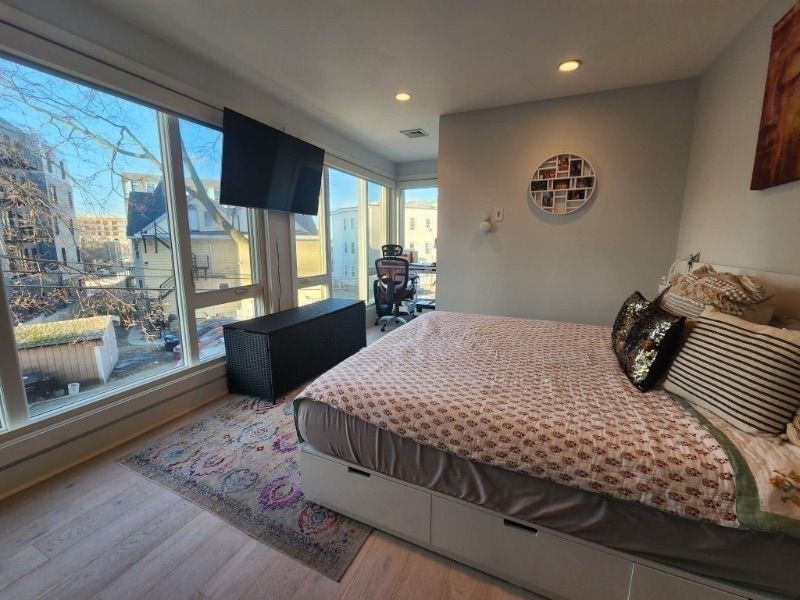 533 Cambridge Street, Unit 105 Boston, MA 02134 - Photo 17 of 32 a bedroom with a bed and glass window