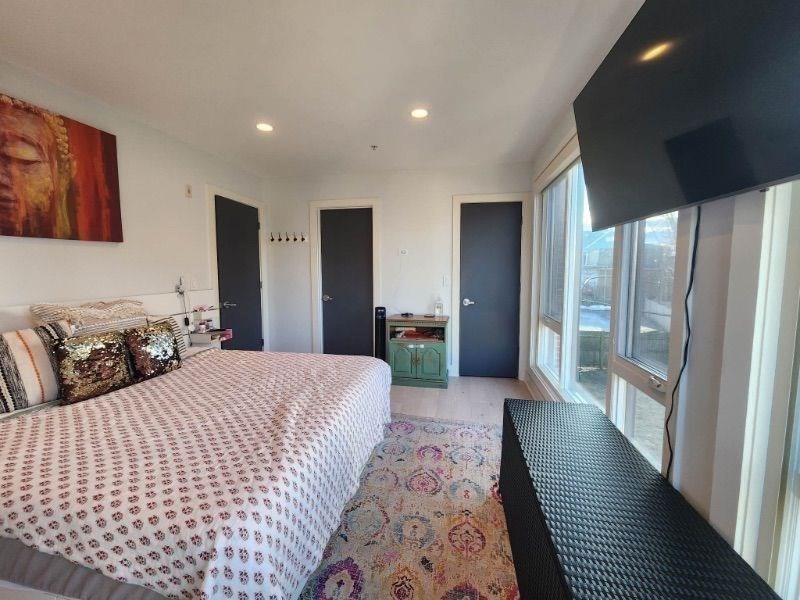 533 Cambridge Street, Unit 105 Boston, MA 02134 - Photo 18 of 32 a large bedroom with bed and a large window