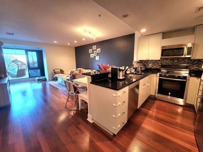 533 Cambridge Street, Unit 105 Boston, MA 02134 - Photo 25 of 32 a kitchen with wooden floors and living room