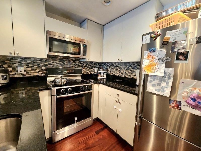 533 Cambridge Street, Unit 105 Boston, MA 02134 - Photo 26 of 32 a kitchen with granite countertop stainless steel appliances a stove a microwave and a refrigerator