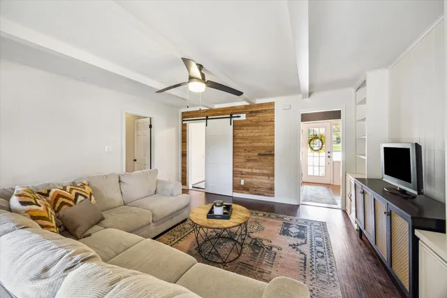 a living room with furniture ceiling fan and a wooden floor