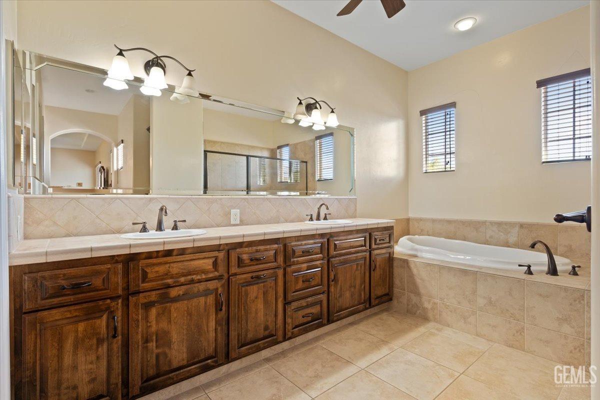 Undisclosed Address Bakersfield, CA 93311 - Photo 27 of 41 a spacious bathroom with a granite countertop double vanity sink a mirror and a bathtub