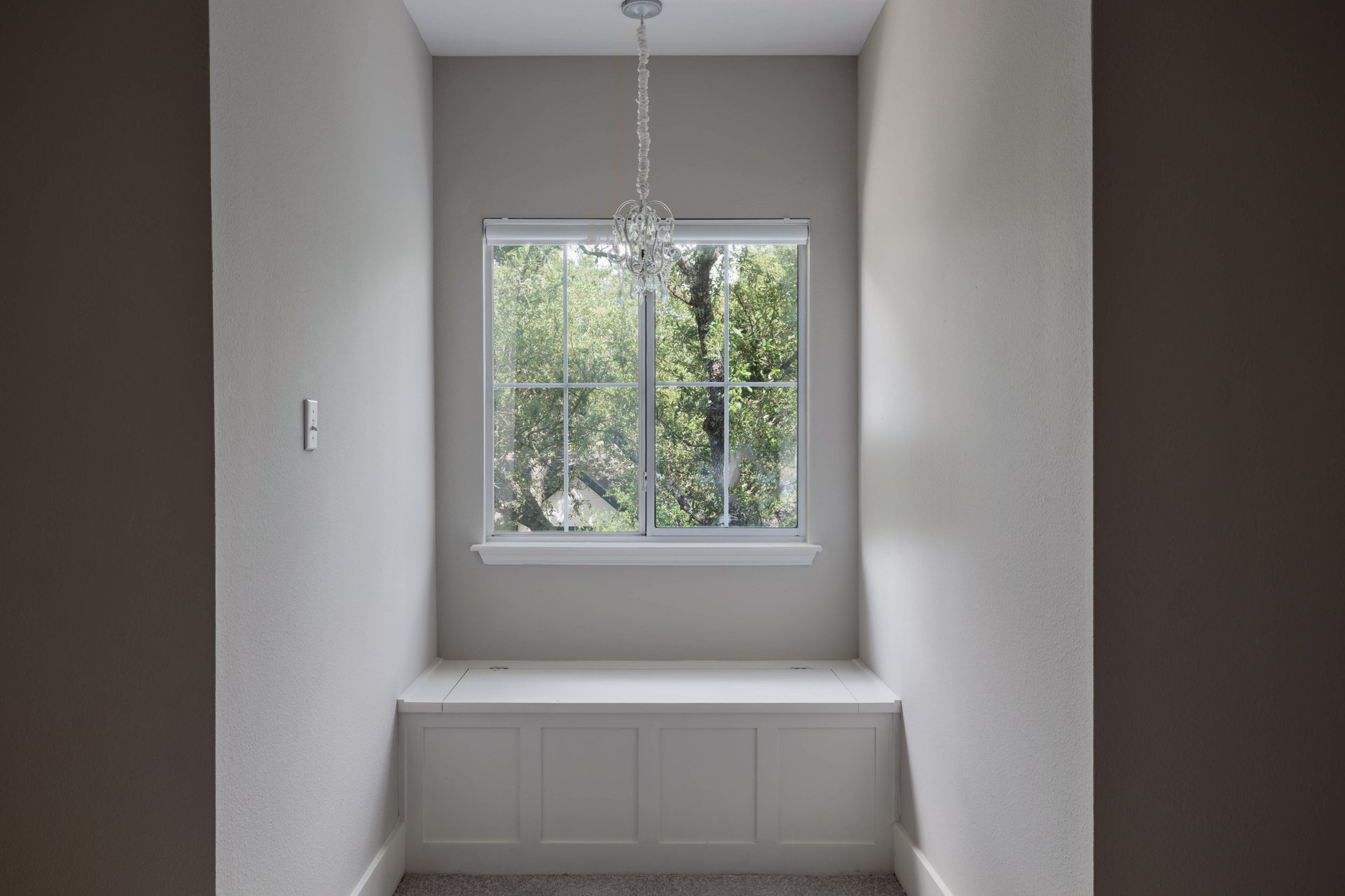 5512 Ballenton Lane Austin, TX 78739 - Photo 29 of 40 A window seat offers a tranquil nook, bathed in natural light and adorned with a delicate chandelier.