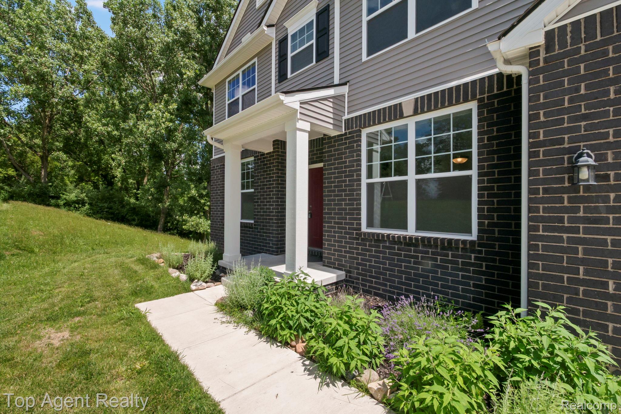 63770 Dequindre Road Washington, MI 48095 - Photo 53 of 61 Two-story exterior featuring dark brick and gray siding