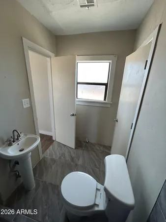 a bathroom with a sink a toilet and mirror