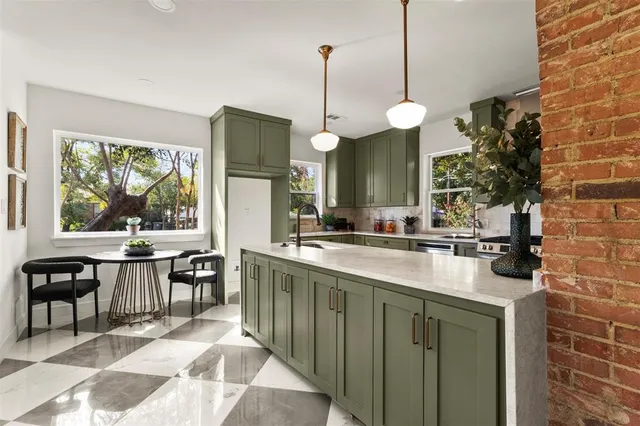 a kitchen with kitchen island granite countertop a sink a counter top space and living room view