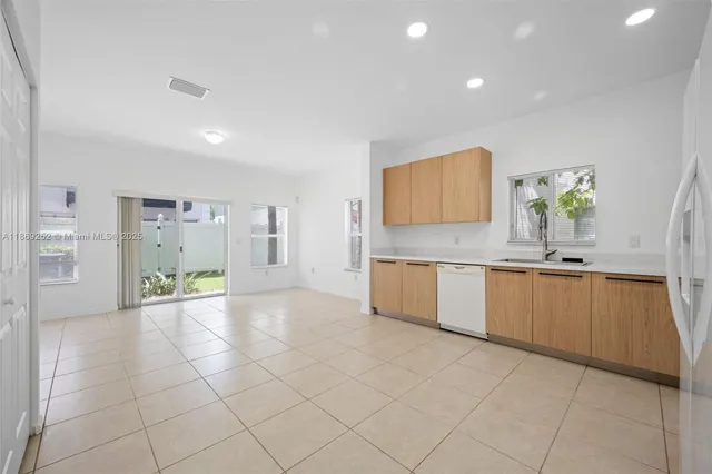 a large white kitchen with a sink and cabinets