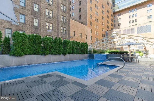 a view of a swimming pool with a bench in front of a house