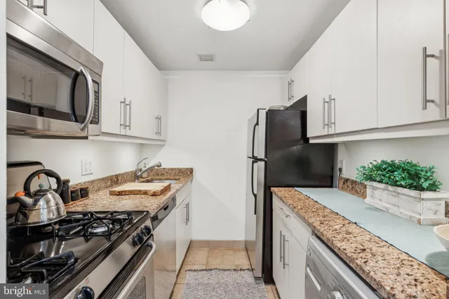a kitchen with stainless steel appliances granite countertop a stove and a refrigerator