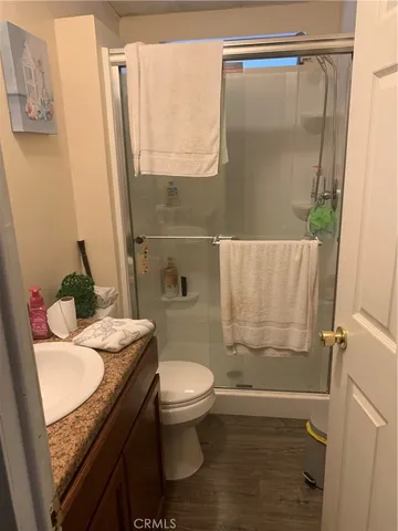 a bathroom with a granite countertop sink toilet and shower