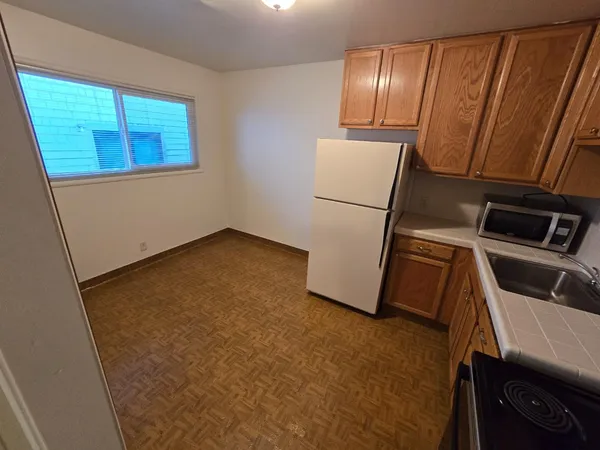 a room with a refrigerator and wooden floor