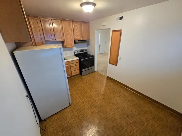 a view of a kitchen with refrigerator and cabinet