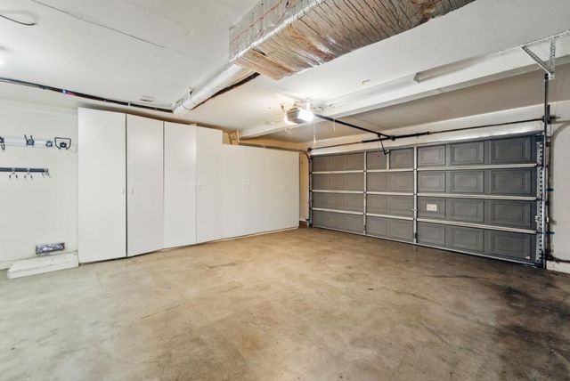 a view of a patio with table and chairs and potted plants and large tree