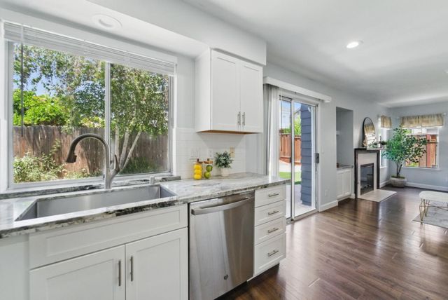 a kitchen with granite countertop white cabinets and stainless steel appliances