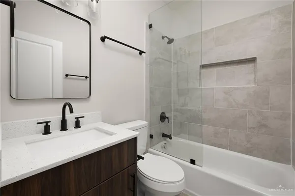 a bathroom with a bathtub shower sink mirror and toilet