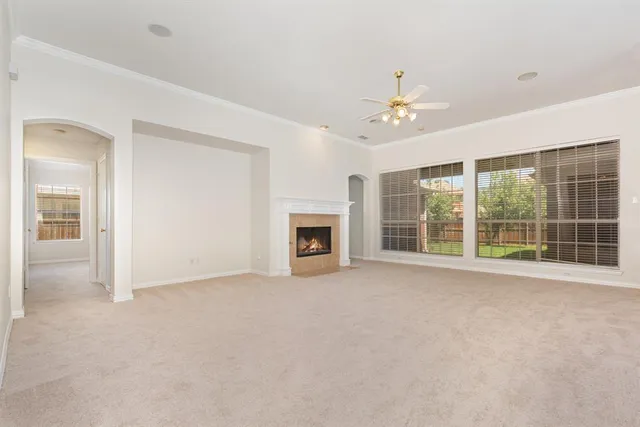 a view of an empty room with a fireplace and a window