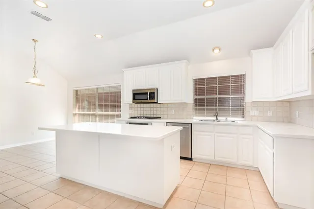a kitchen with stainless steel appliances a stove sink and cabinets