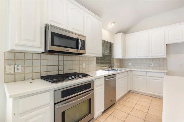 a kitchen with cabinets stainless steel appliances and a sink