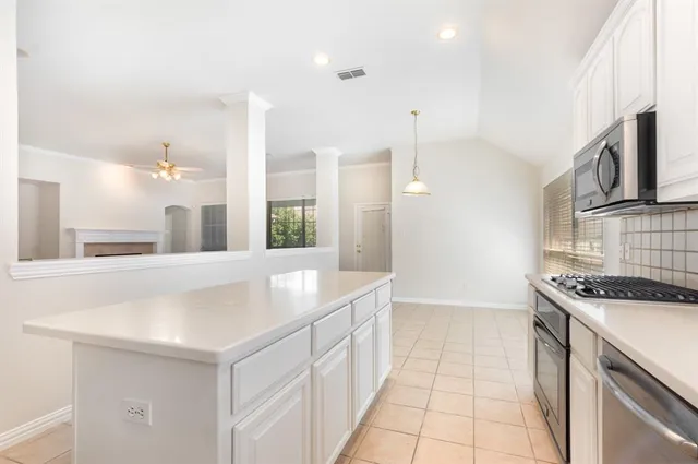 a kitchen with stainless steel appliances granite countertop a sink and a stove