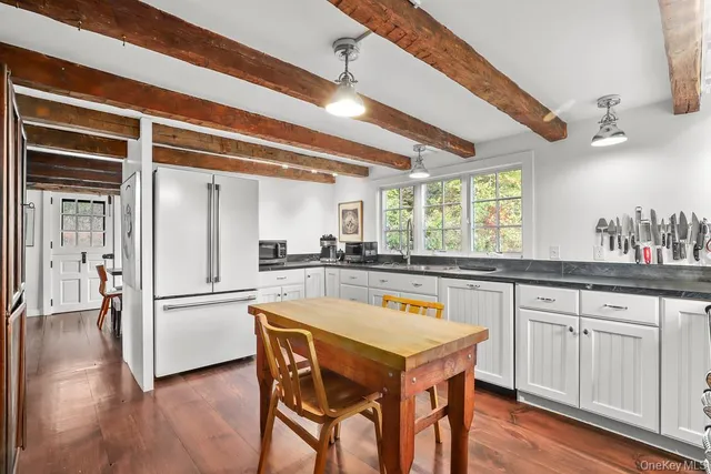 a kitchen with a table chairs refrigerator and cabinets