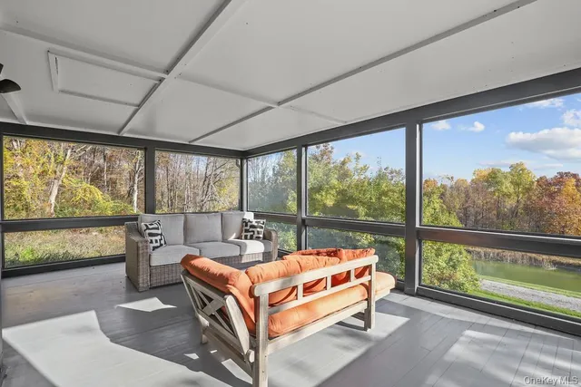 a bed sitting in a balcony next to a large window