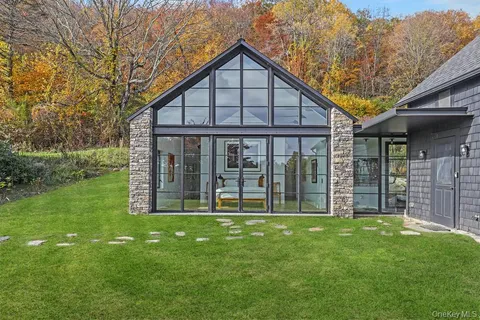 a view of a house next to a big yard and large trees